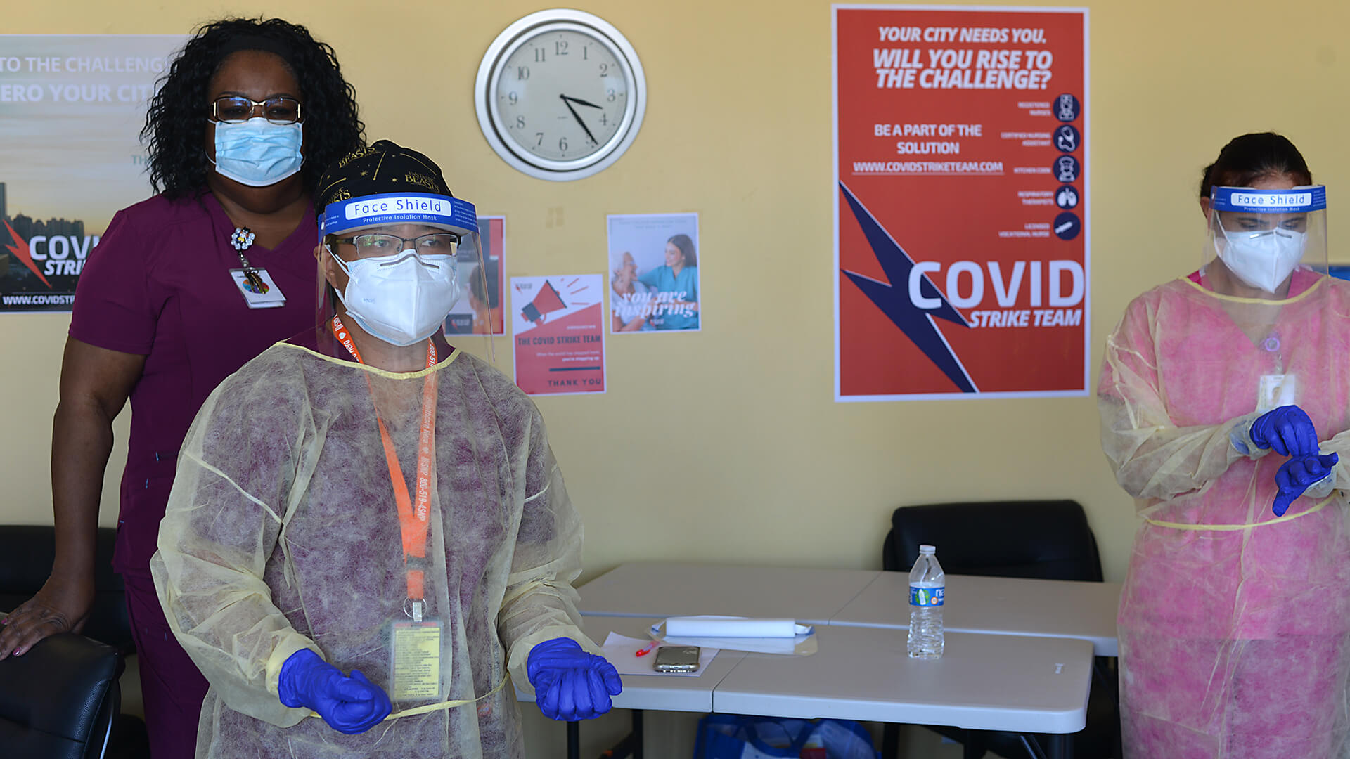 Monica Washington ties a gown for Celia Lagay during a demonstration of how to properly do personal protective equipment (PPE) to prevent against COVID-19 at the Eastland Subacute and Rehabilitation Center in El Monte, California.