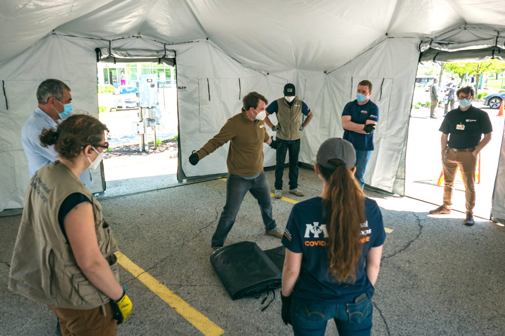 The International Medical Corps team prepares to move medical equipment into the tent to make it fully operational for serving patients.
