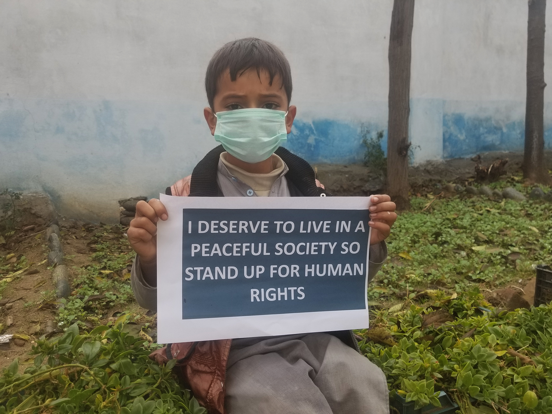 A young advocate in the Khyber Pakhtunkhwa province, Pakistan, carries a sign to convey his message on International Human Rights Day.
