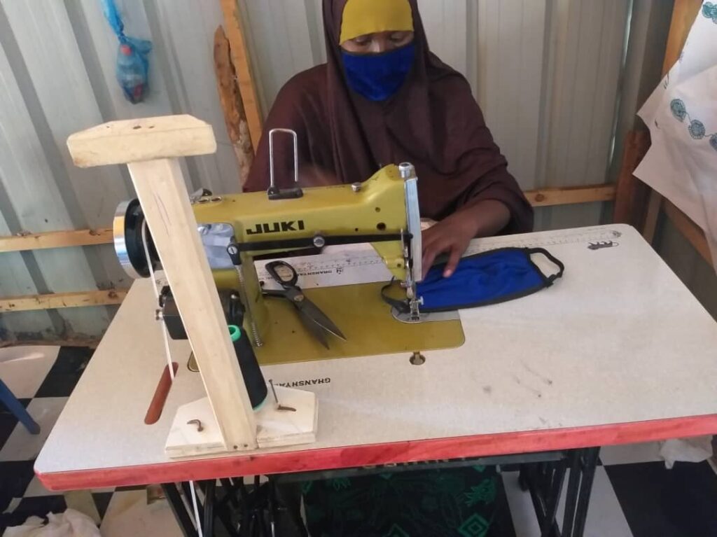 Maryan Abdi Mohammed sews face masks that she will sell in the local market.