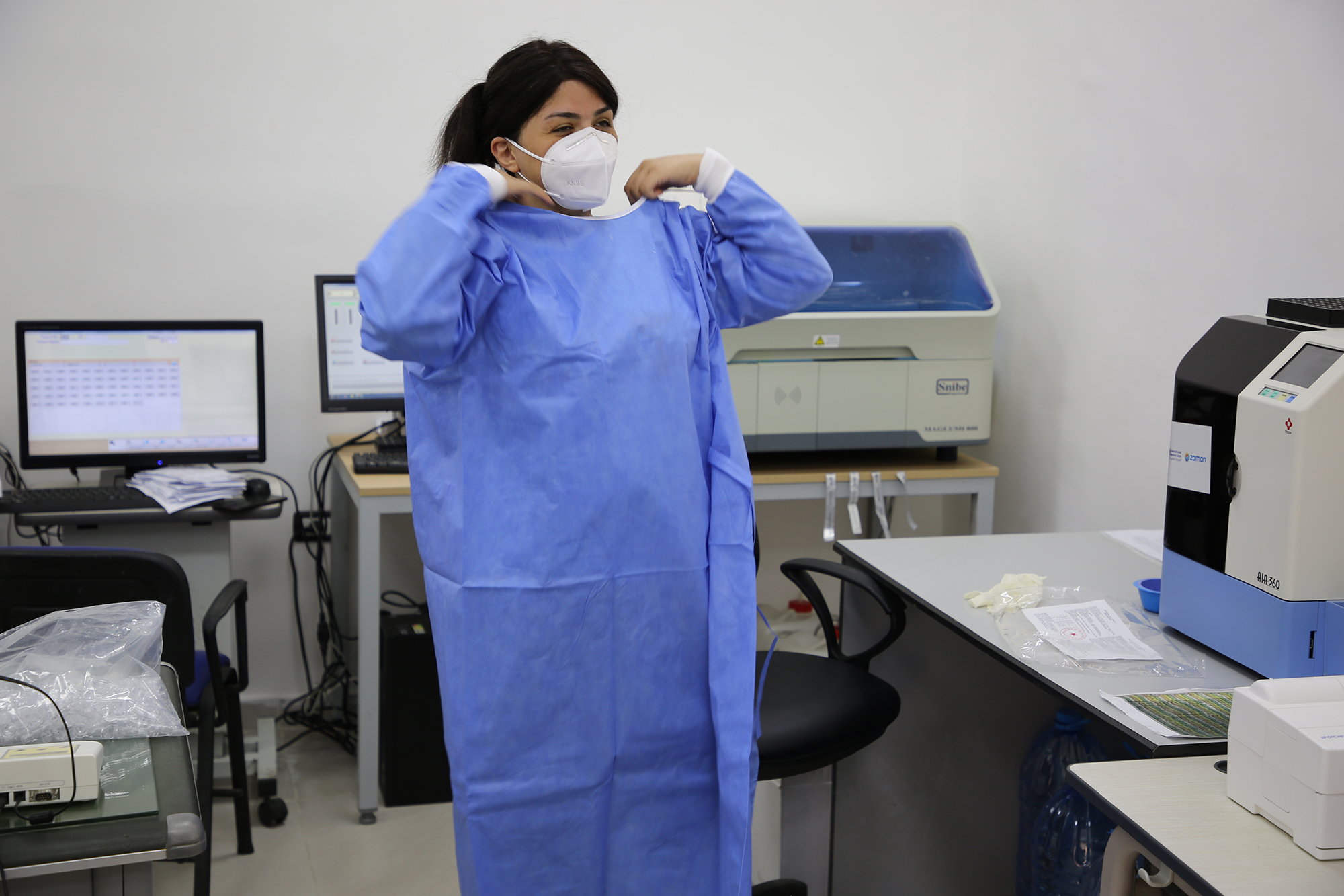 The lab technician at Karagheusian PHCC dons personal protective equipment (PPE) donated by Zaman Foundation.