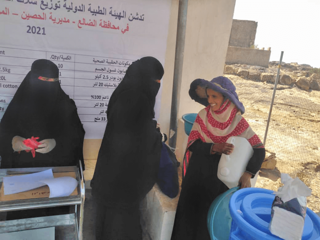 Members of our staff distribute hygiene kits to residents of Al-Hussain District in Al-Dhale Governorate. In this photo, a grateful resident tucks a new plastic jerry can—part of each kit—under her arm.