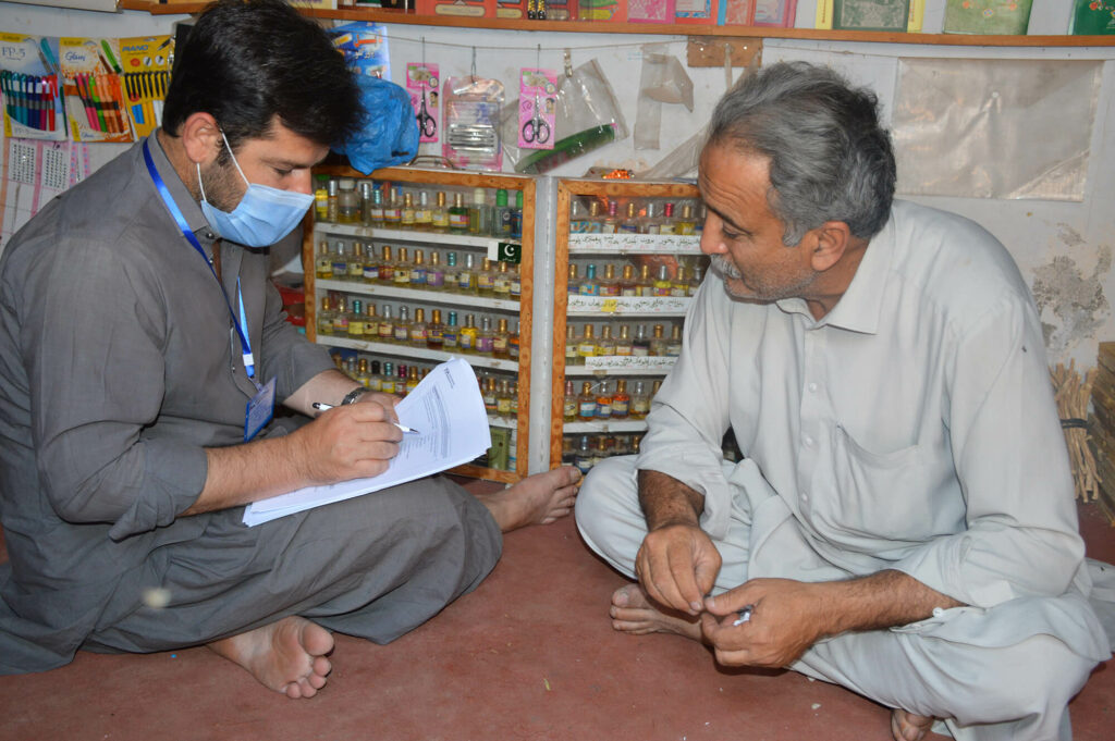 A data collector interviews a male community member.