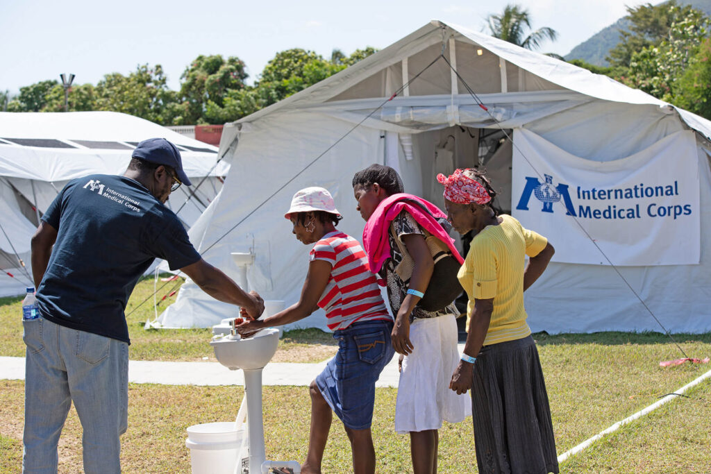 Patients wash their hands at the International Medical Corps field hospital in Aquin.
