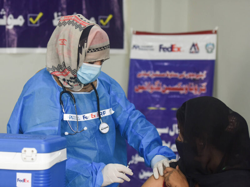 A young woman receives a vaccine at the Abasyn University mobile vaccination camp.