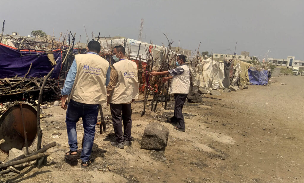 An International Medical Corps mobile team surveys damage to a family tent gutted by fire at the Al Qahera displacement camp.