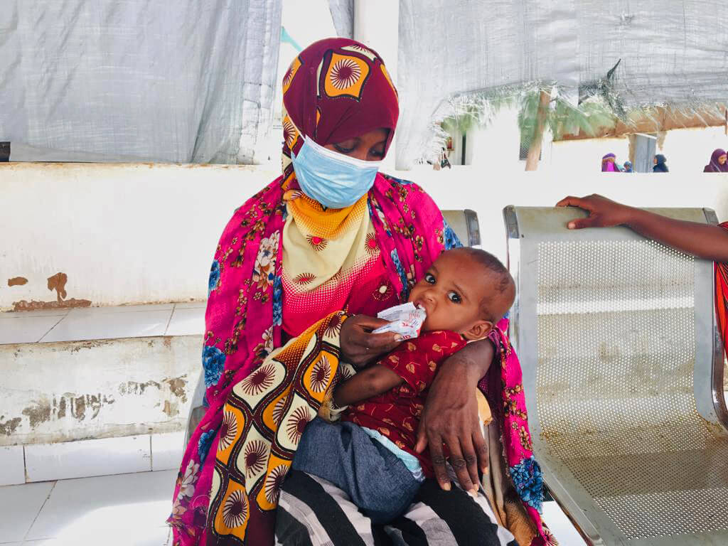 A Somali mother gives her one-year-old boy ready-to-use therapeutic food at Galkayo Hospital in central Somalia. The food provides vital nutrients children need to recover from malnutrition.