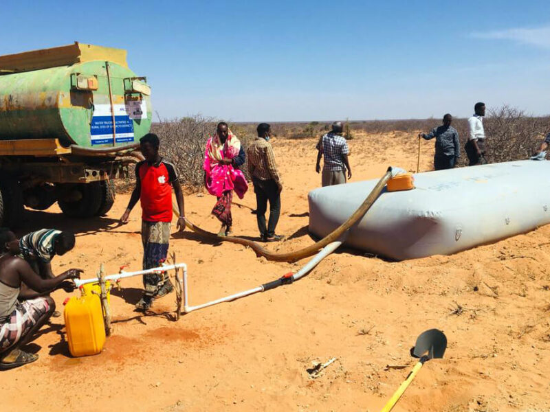 Residents of Qarsooni village located outside Galkayo, Somalia, draw water from a bladder filled with water we trucked into the area. (Photo by Adan Sheikhnur Omar.)
