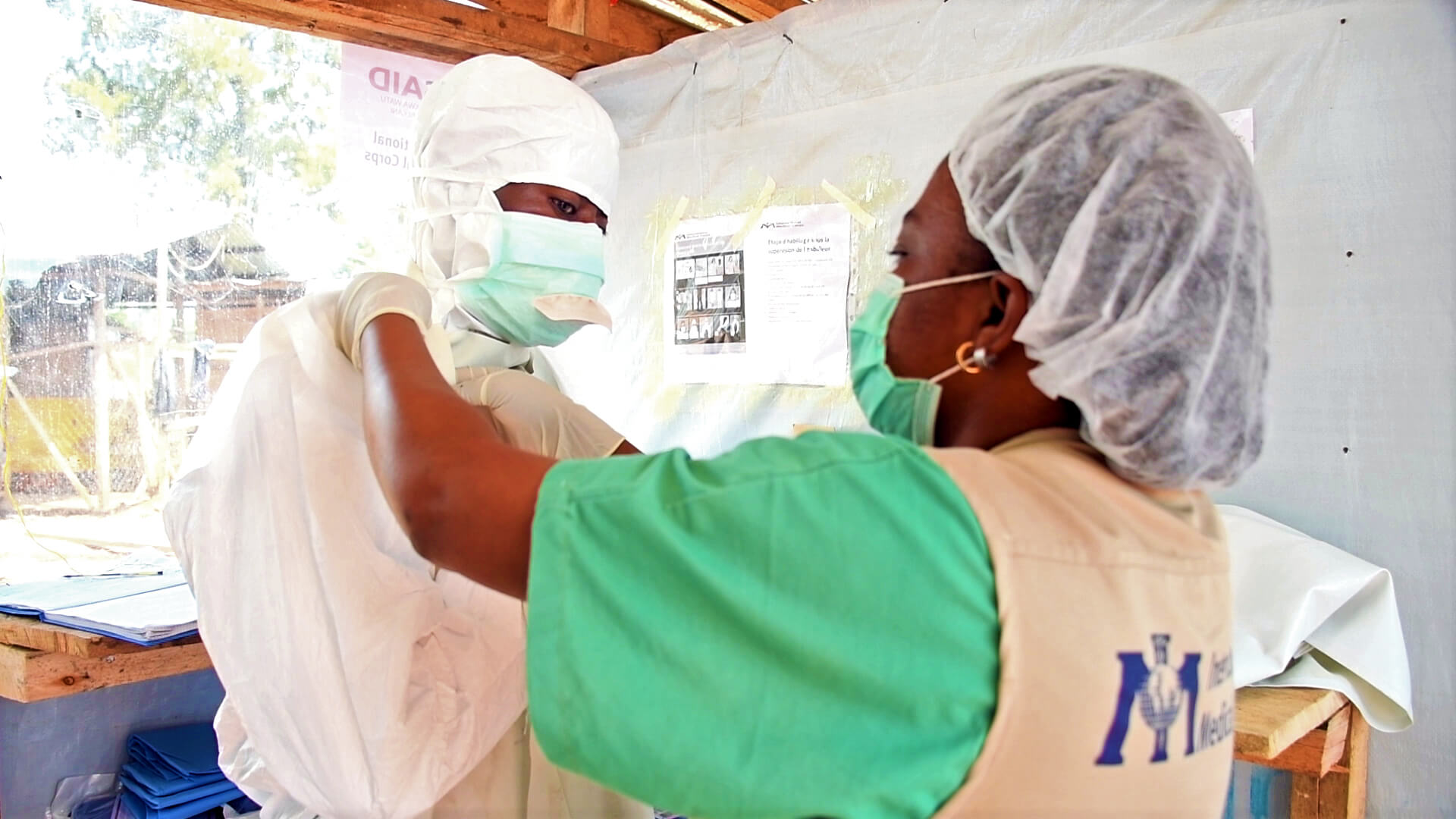 Dr. Lina Kashibura helps a staff member prepare to treat Ebola patients.