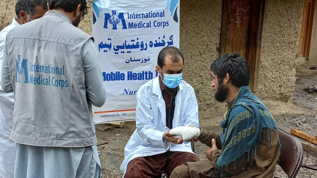 An International Medical Corps doctor bandages a patient in Kamdish, Nuristan.