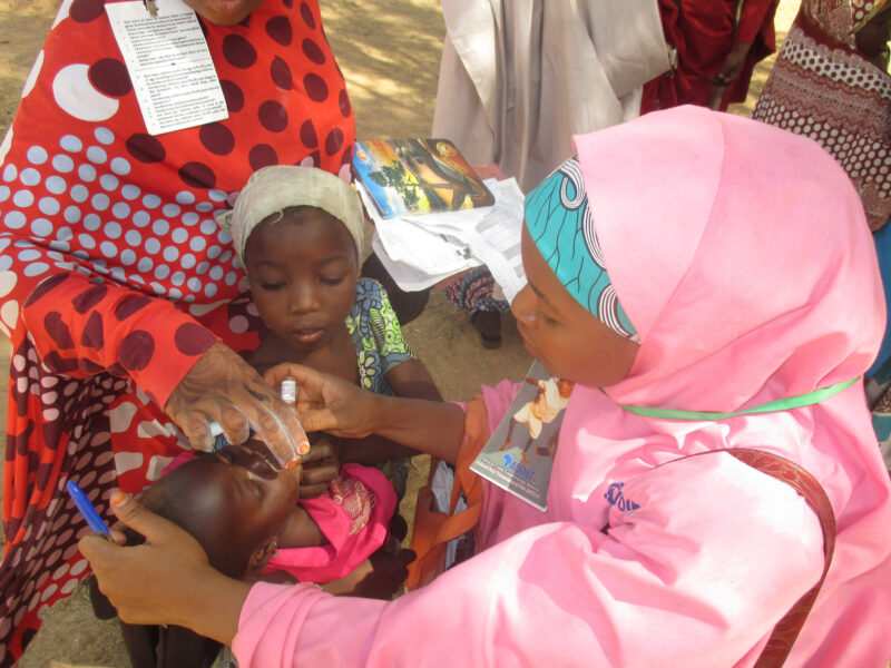 A CGPP worker administers a polio vaccine to a Nigerian child.