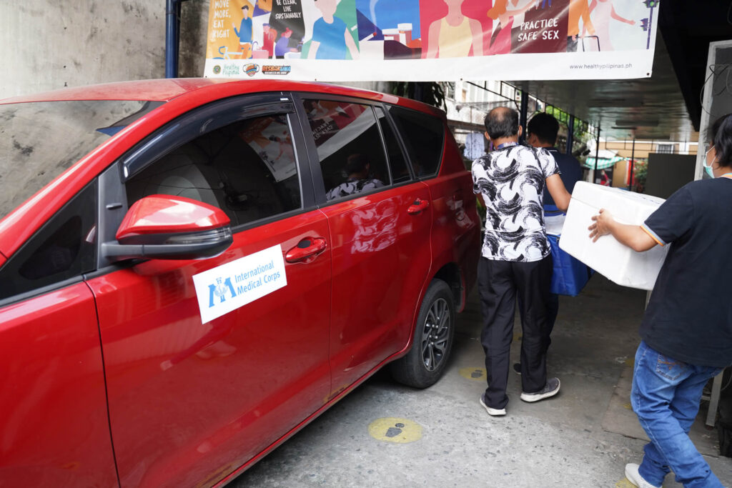Manila Health Department staff loads vaccines into a service vehicle provided by International Medical Corps.