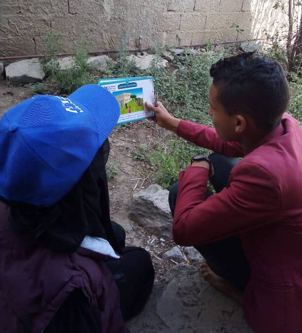 Rezk Allah presents instruction material to a local resident.