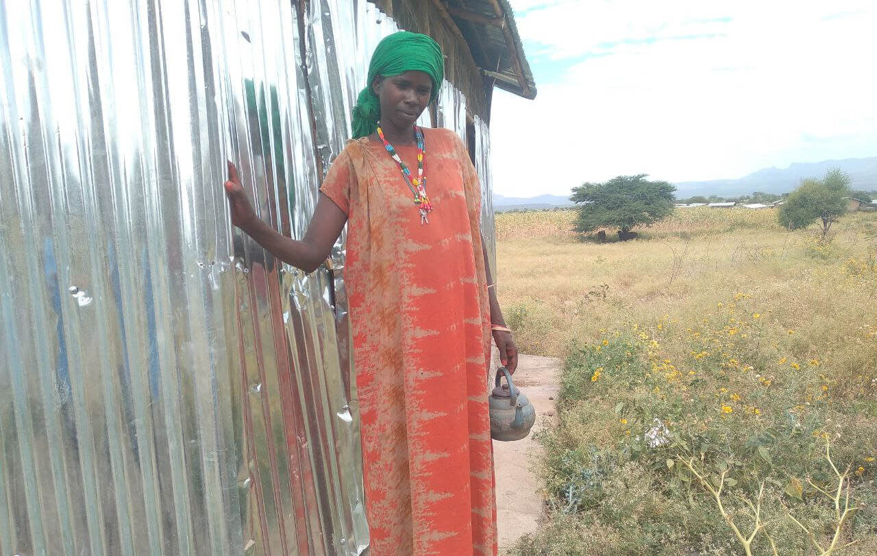 Asha Ali stands next to a communal latrine in Ethiopia.
