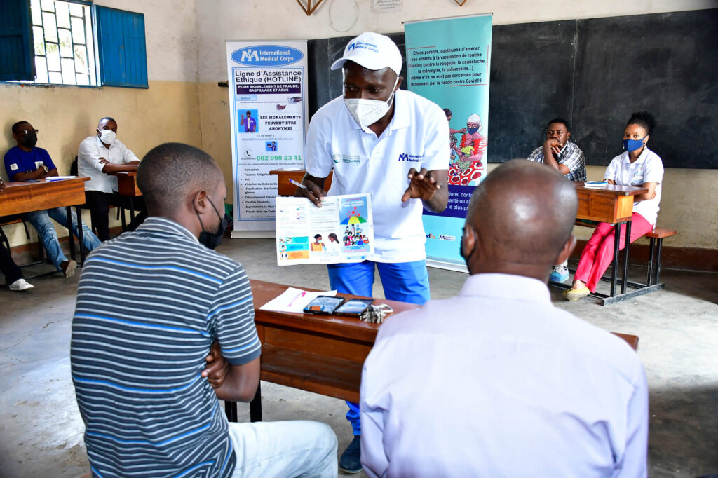 Arthur Amani of International Medical Corps conducts a sensitization activity with motorcycle taxi drivers after their vaccination against COVID-19.