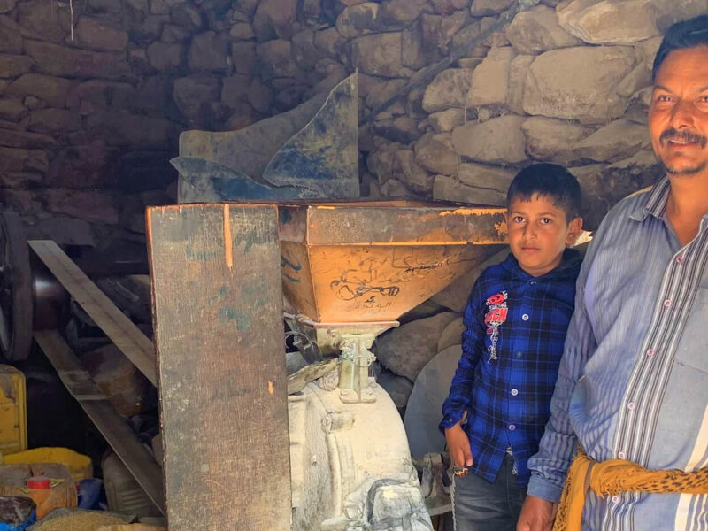 Nasir inside of his mill with his son Mohammed. Nasir was able to reopen his mill thanks to cash assistance from International Medical Corps.