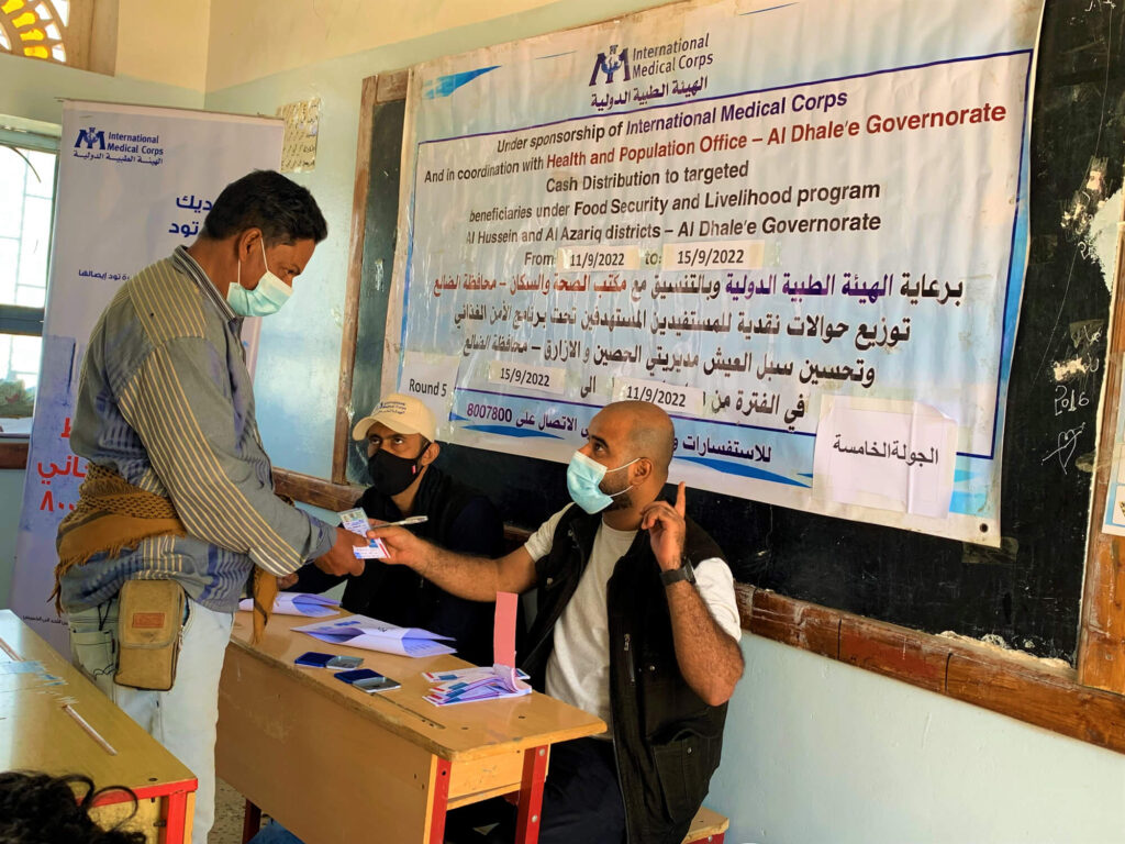 Nasir receives a voucher from International Medical Corps staff during the fifth round of cash distribution.