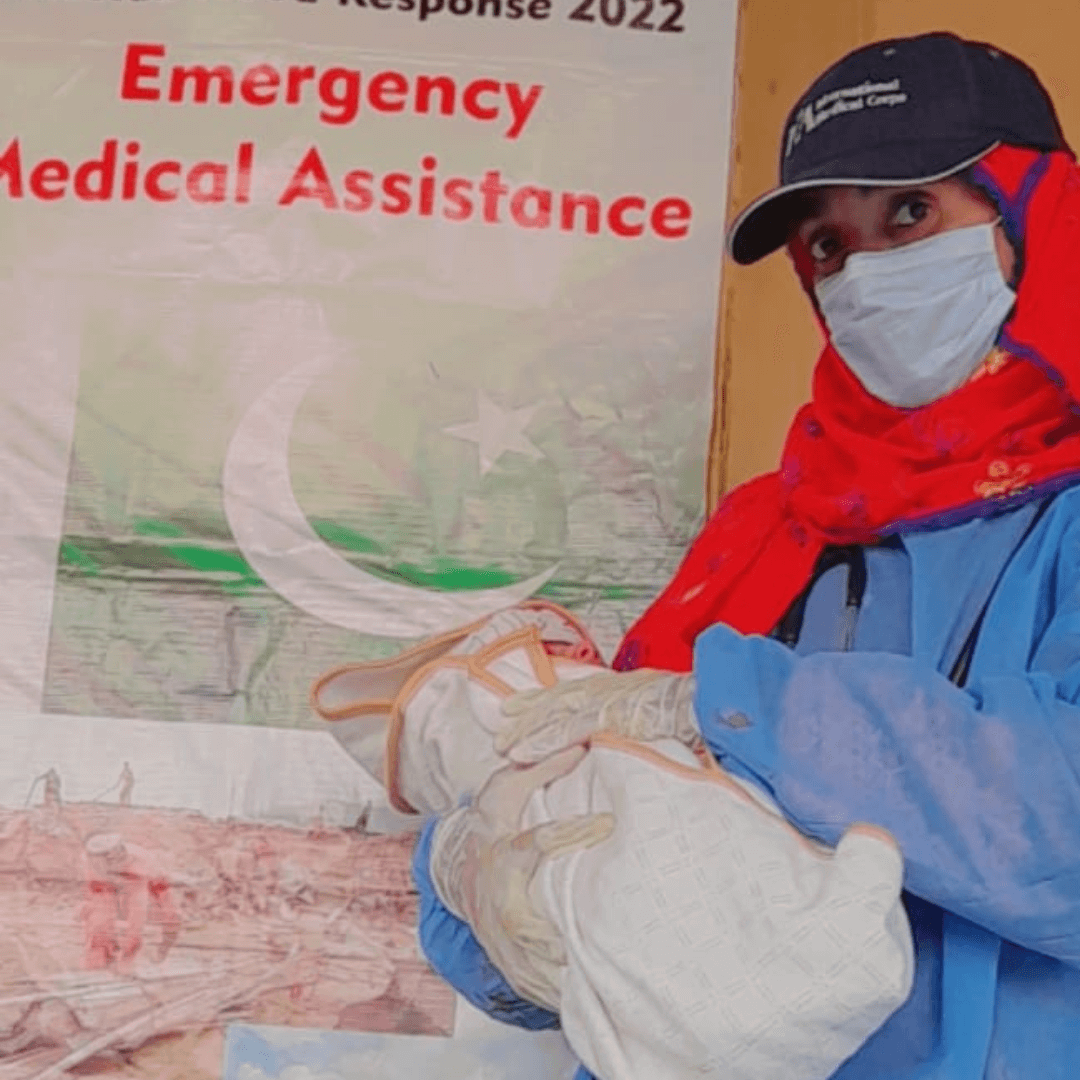 Nafidat, an International Medical Corps health worker specializing in women, holds a baby girl after assisting with a successful delivery.