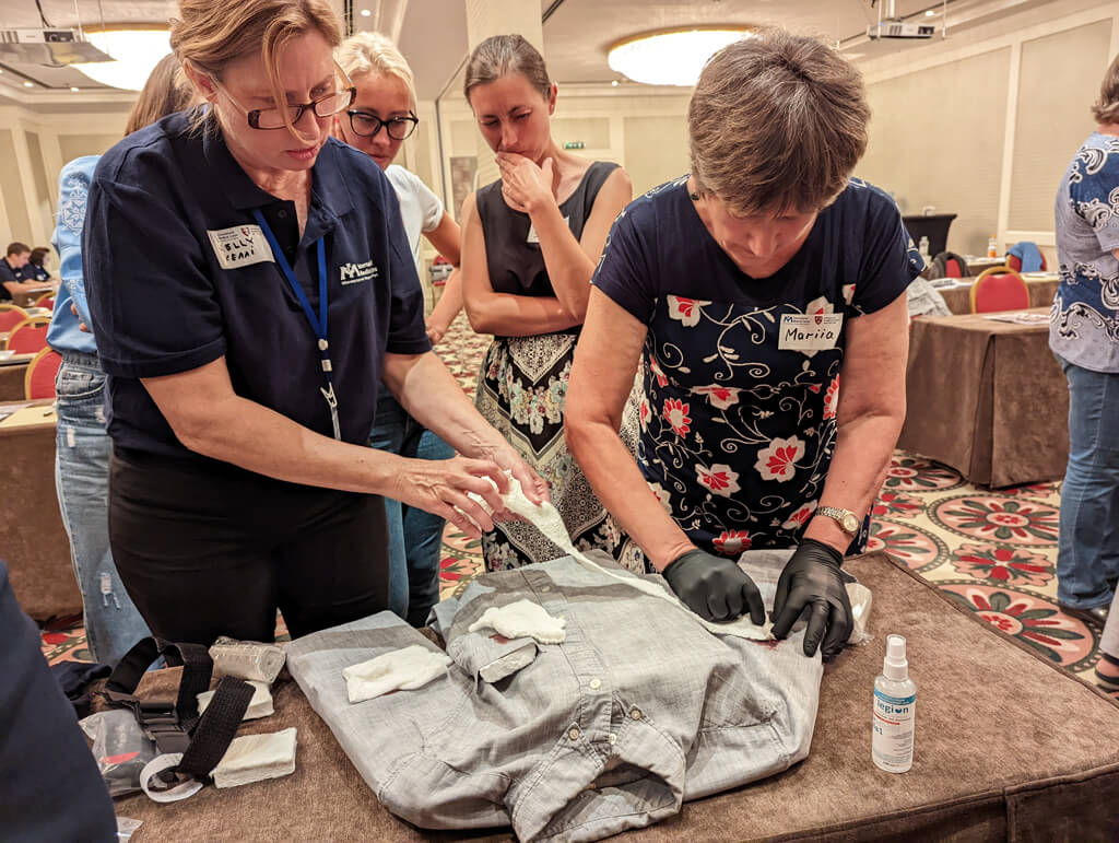 Instructor Kelly Hanzlik teaches bleeding-control techniques to a participant during a Stop the Bleed® (STB) course.
