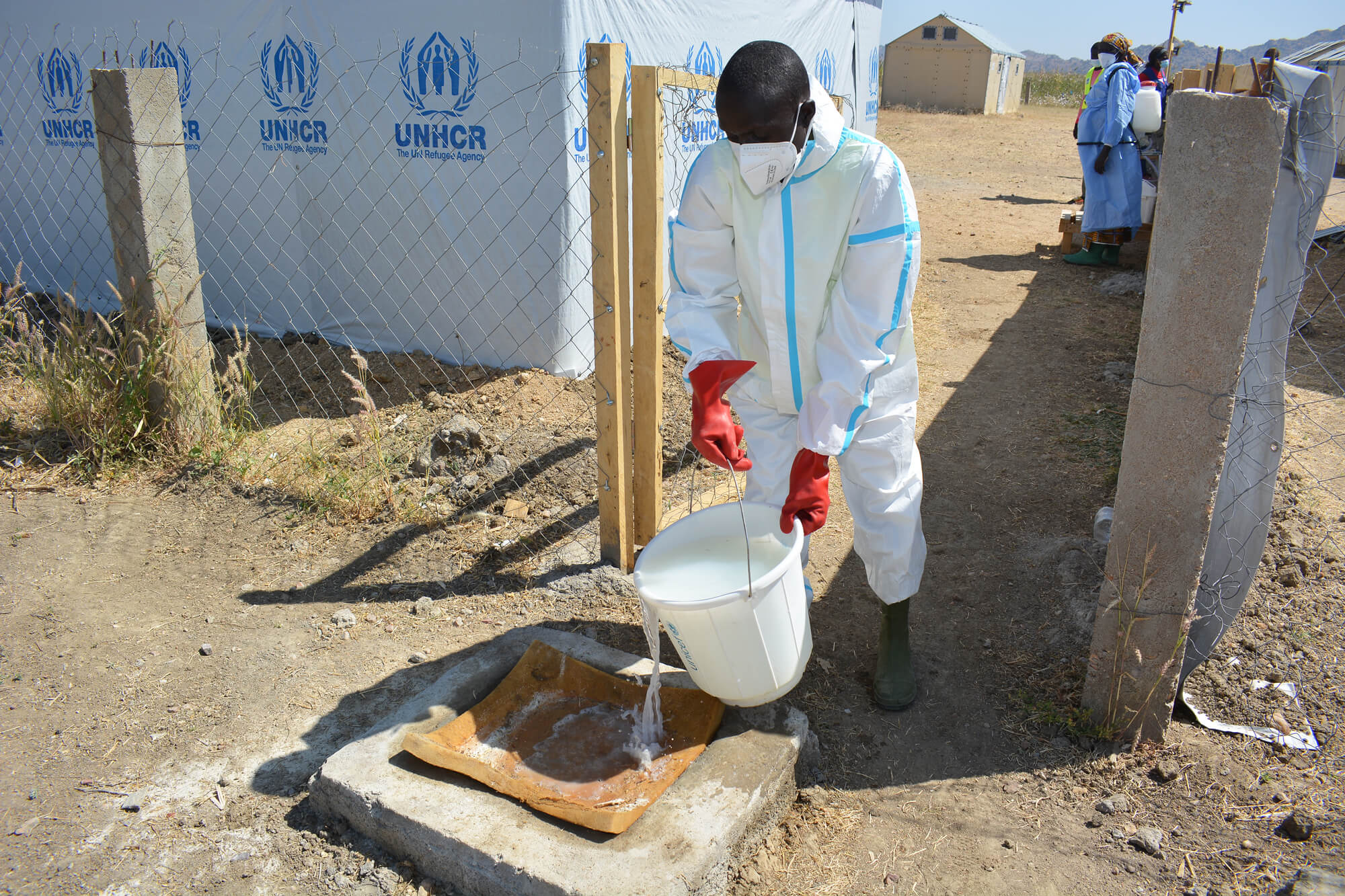 Modu Modu, a community health worker, disinfects a mat in the cholera treatment center with a diluted chlorine solution.