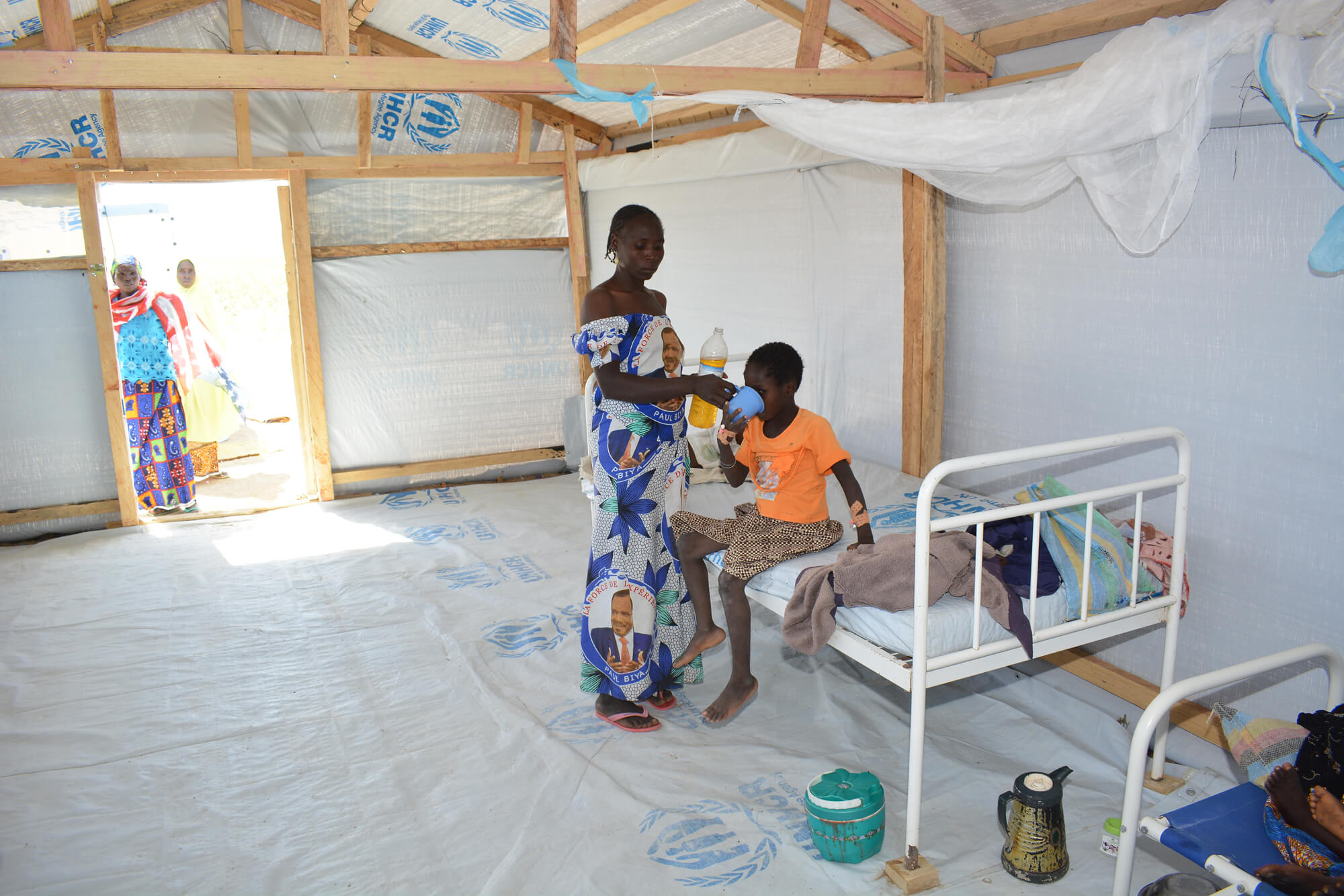 A cholera patient’s mother provides oral rehydration solution to her child in the cholera treatment center.