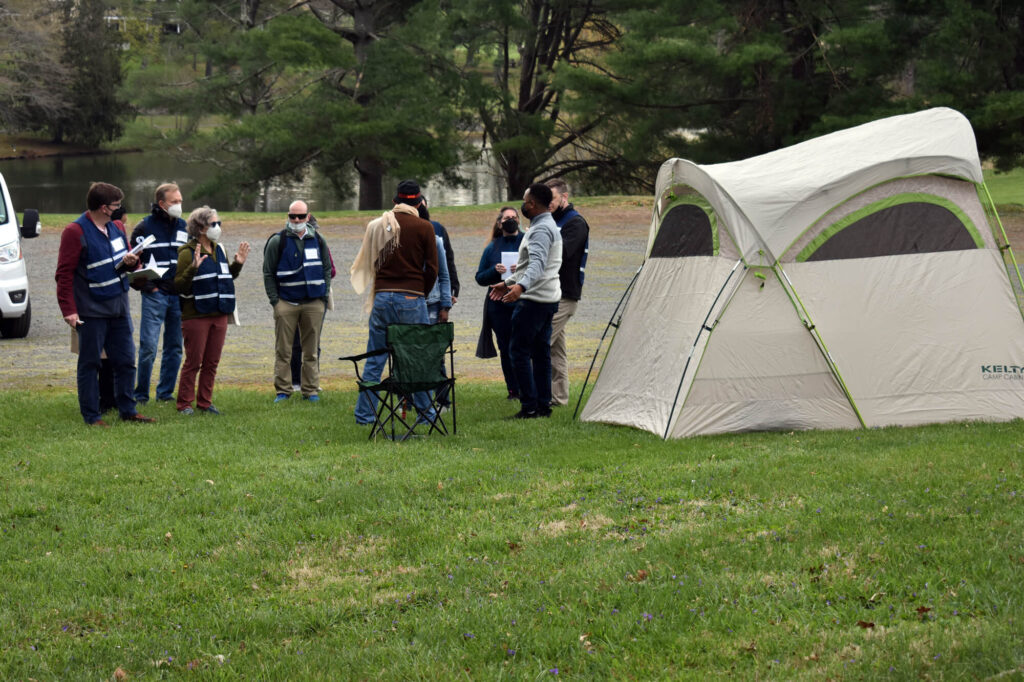 Participants at a disaster-simulation exercise gather information from “survivors” at what remains of their coastal “village,” which according to the scenario provided to participants, had been mostly destroyed a few days earlier by an earthquake and tsunami. The simulation was conducted at a retreat in Airlie, VA.