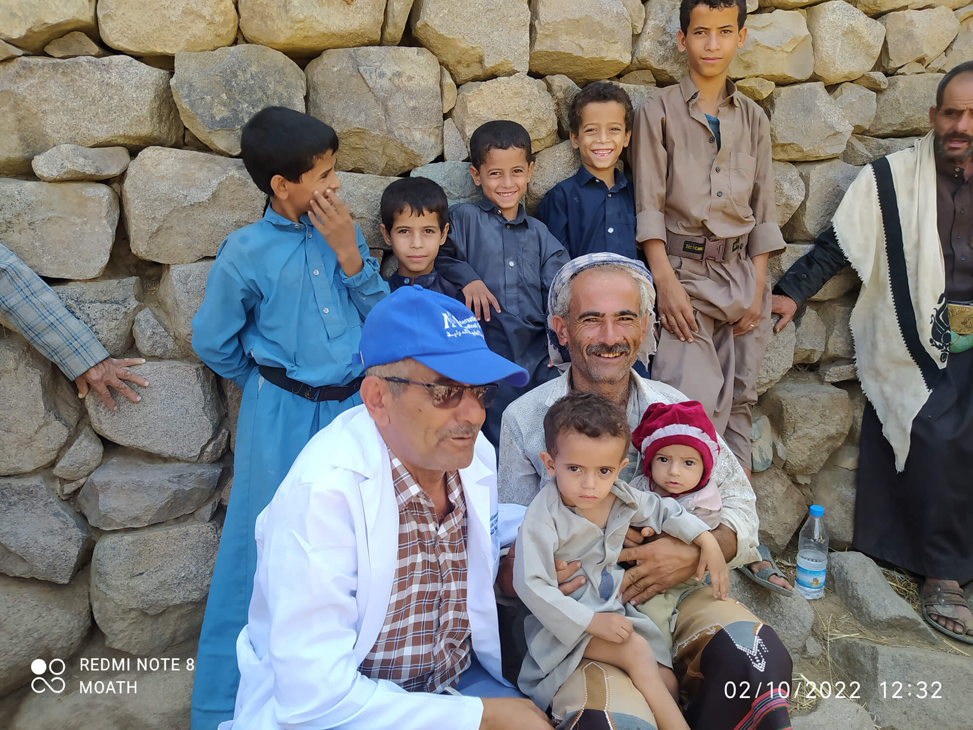 Faisal, a recipient of International Medical Corps' unconditional cash transfer, is shown with seven of his children.