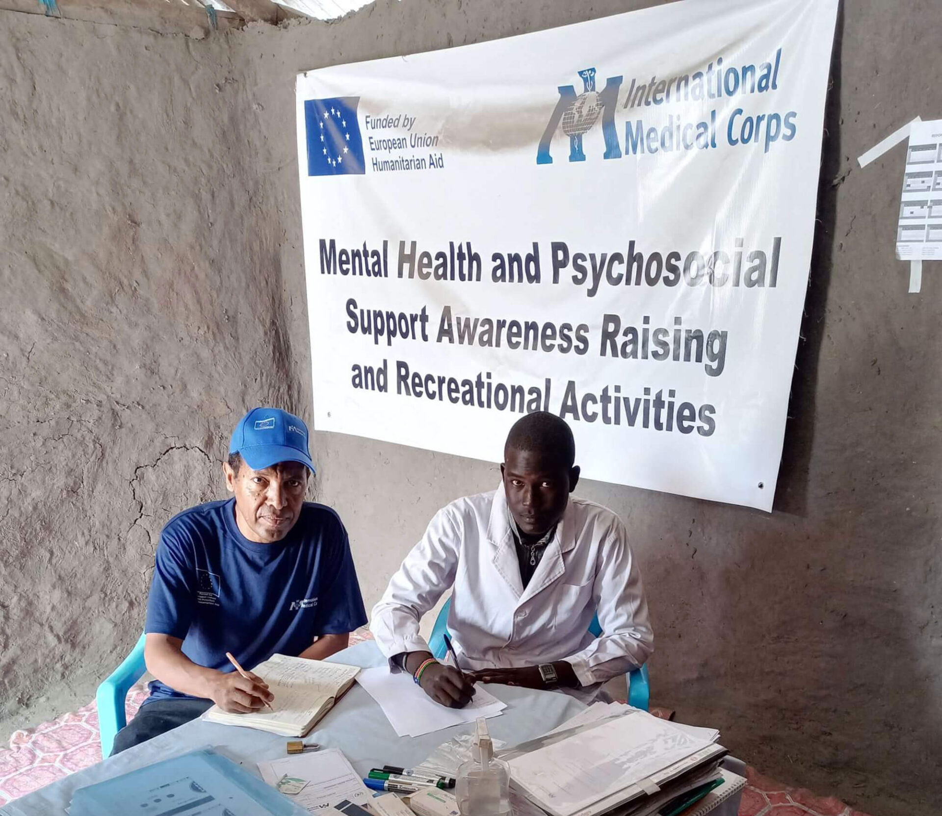 Hailu Bekele (left) meets with a mental health clinical officer to discuss possible improvements to the mental health care program in Kurwai.