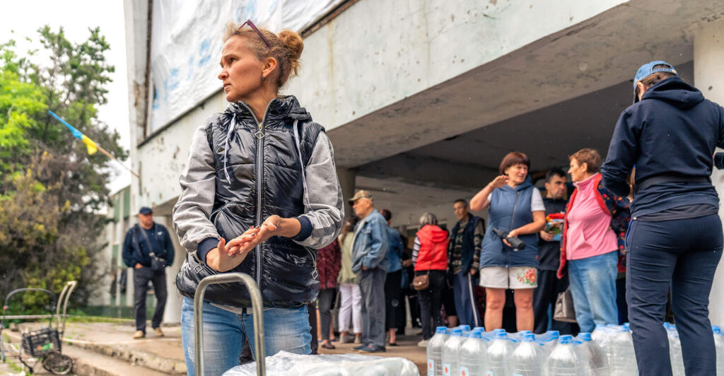 A woman in Novovoronsovka village receives clean water and supplies from International Medical Corps.