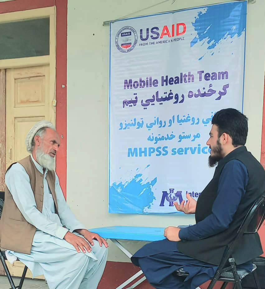 An International Medical Corps staff member (right) provides a community member with mental health and psychosocial support.