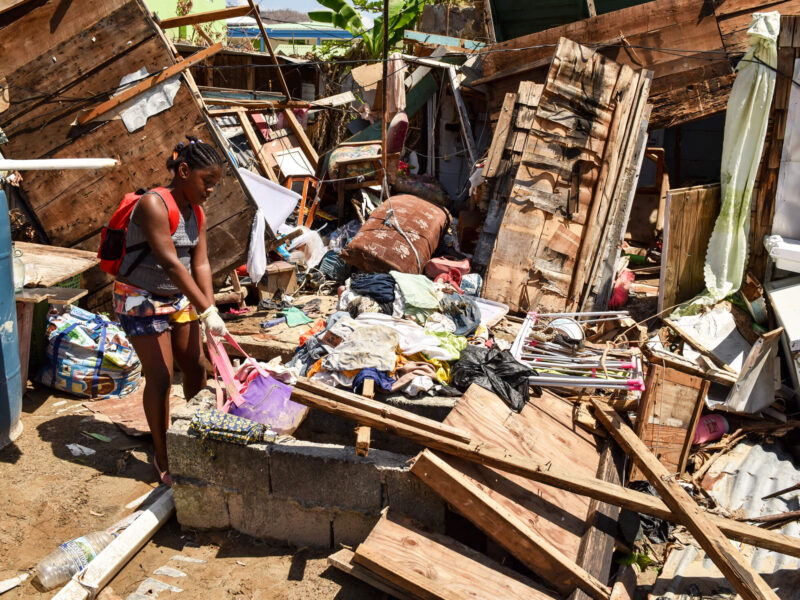 A woman picks through the remnants of a building destroyed by 2017’s Hurricane Maria, a Category 5 storm with winds of more than 175 mph that devastated communities across the Caribbean, caused more than $91 billion dollars in damage and killed more than 3,000 people.