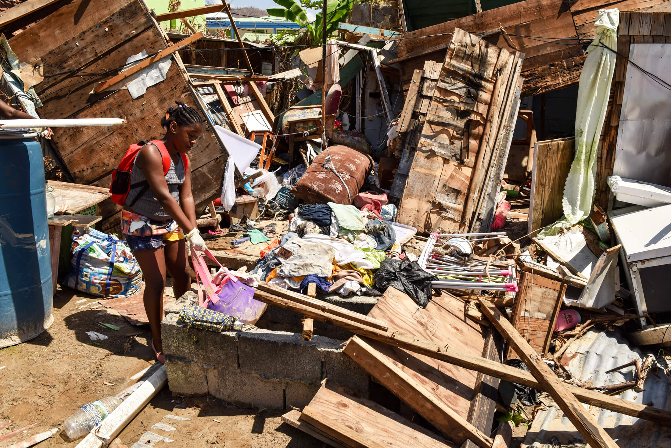 A woman picks through the remnants of a building destroyed by 2017’s Hurricane Maria, a Category 5 storm with winds of more than 175 mph that devastated communities across the Caribbean, caused more than $91 billion in damage and killed more than 3,000 people.