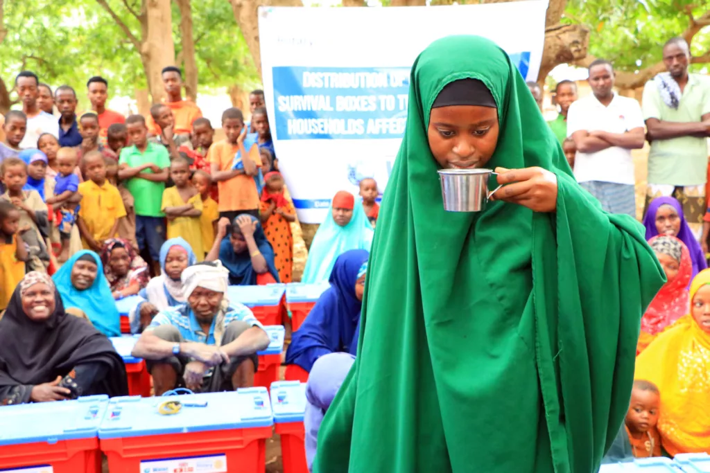 A young woman samples the purified water.