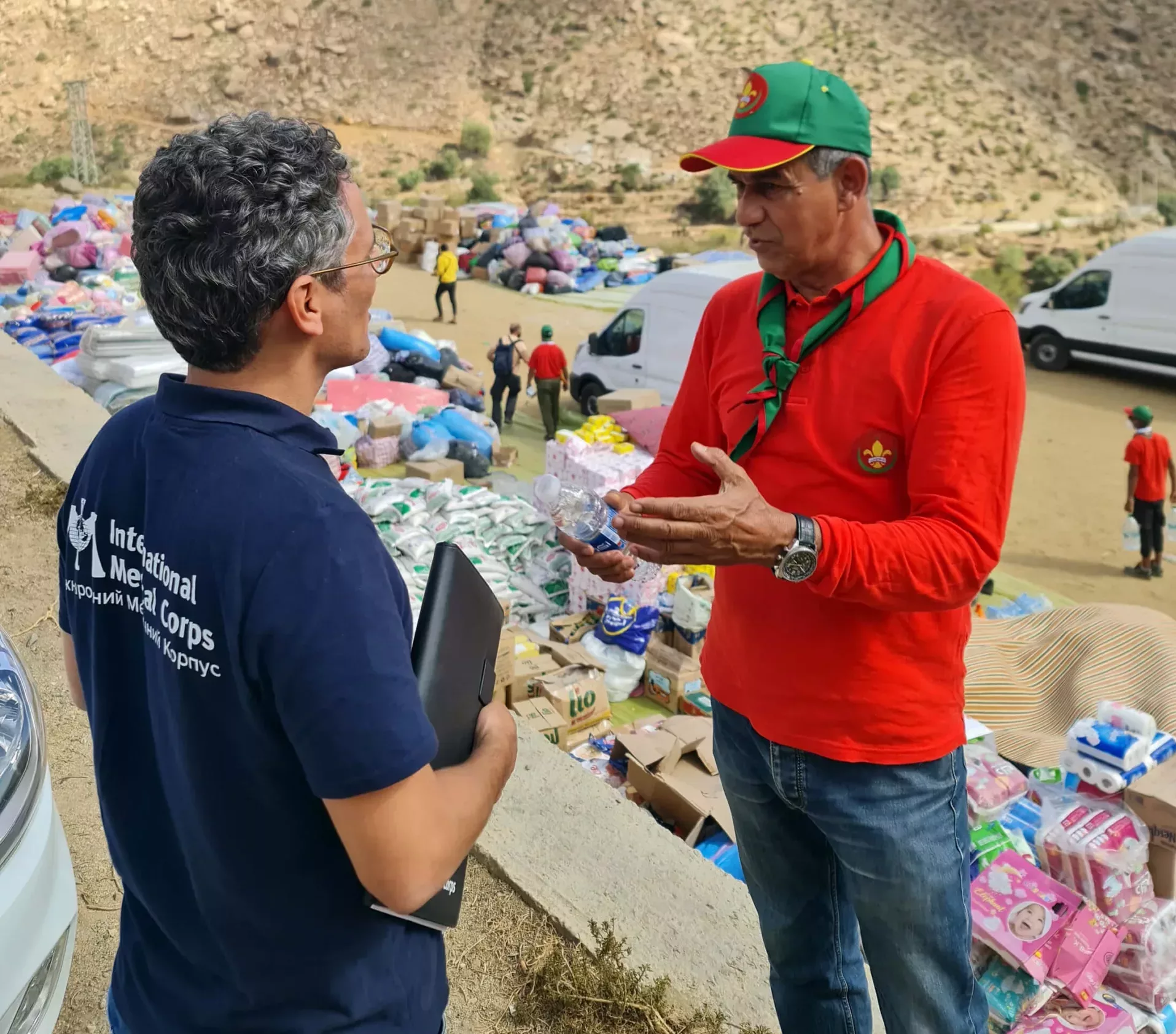 International Medical Corps’ Emergency Response Team Medical Coordinator meets with a member of the Scouts of Morocco at the distribution in Falghous.