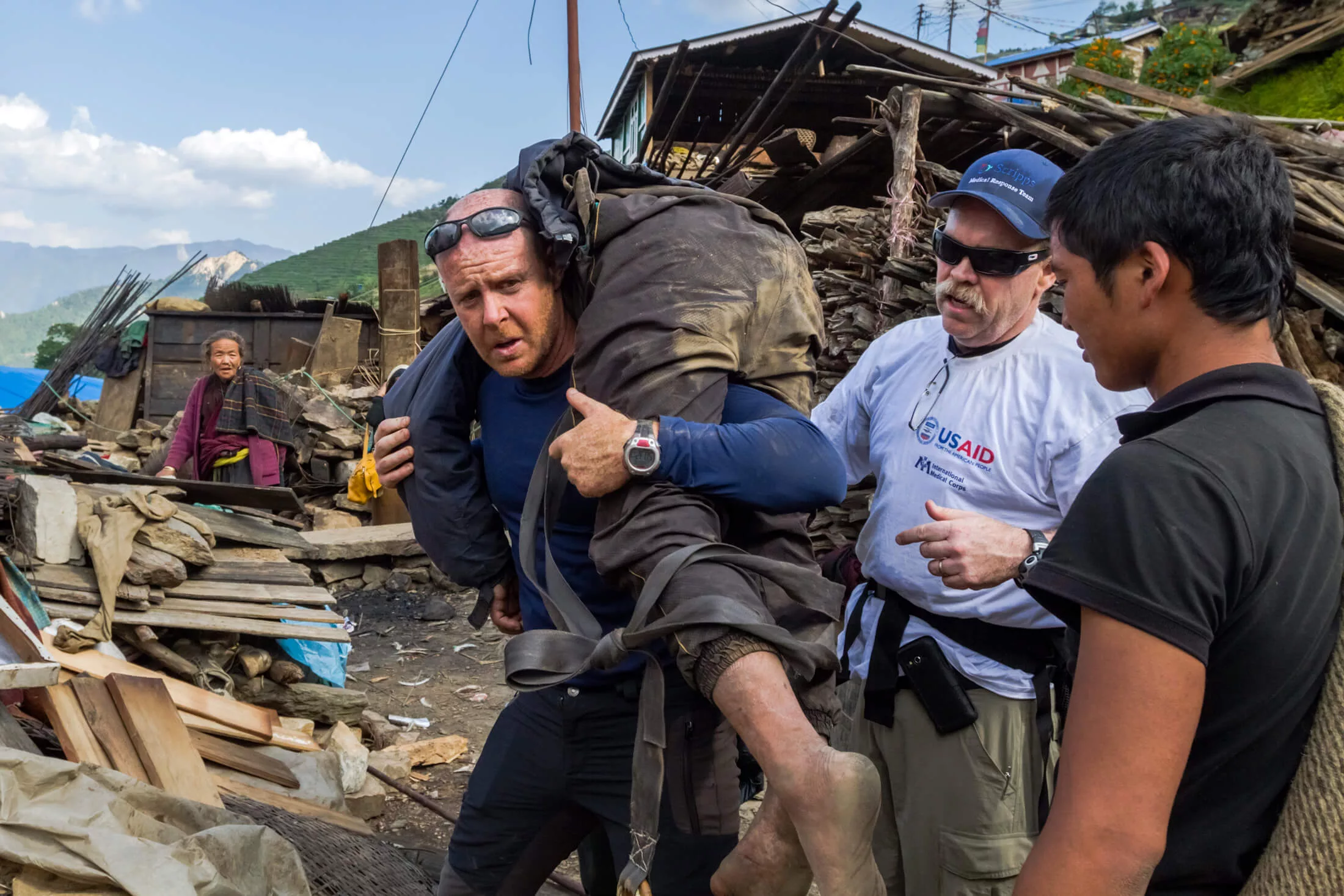 Dr. Michael Karch carries an injured man uphill during a rescue mission in Nepal in 2015 after the devastating earthquake there.