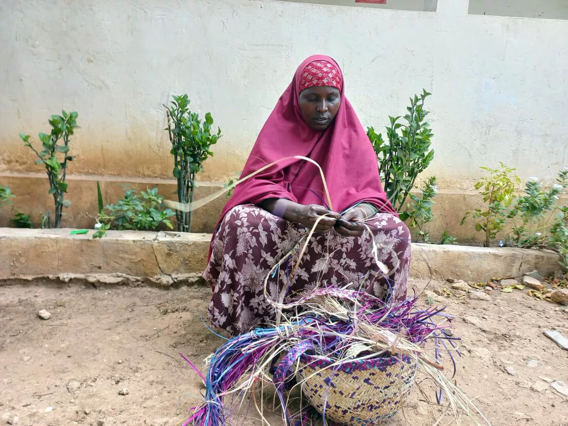 Maryan weaves a basket at the WGSS in Jowhar, Somalia.