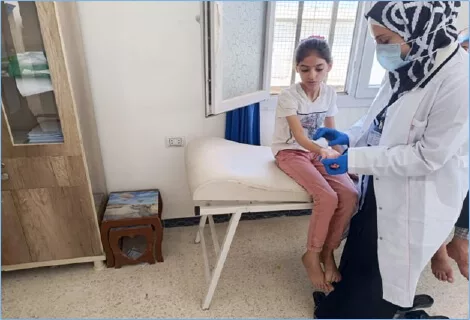 SYR_the-mobile-PTR-unit’s-physical-therapist-assists-a-child-with-hand-therapy-at-the-Kafr-Takharim-surgical-hospital