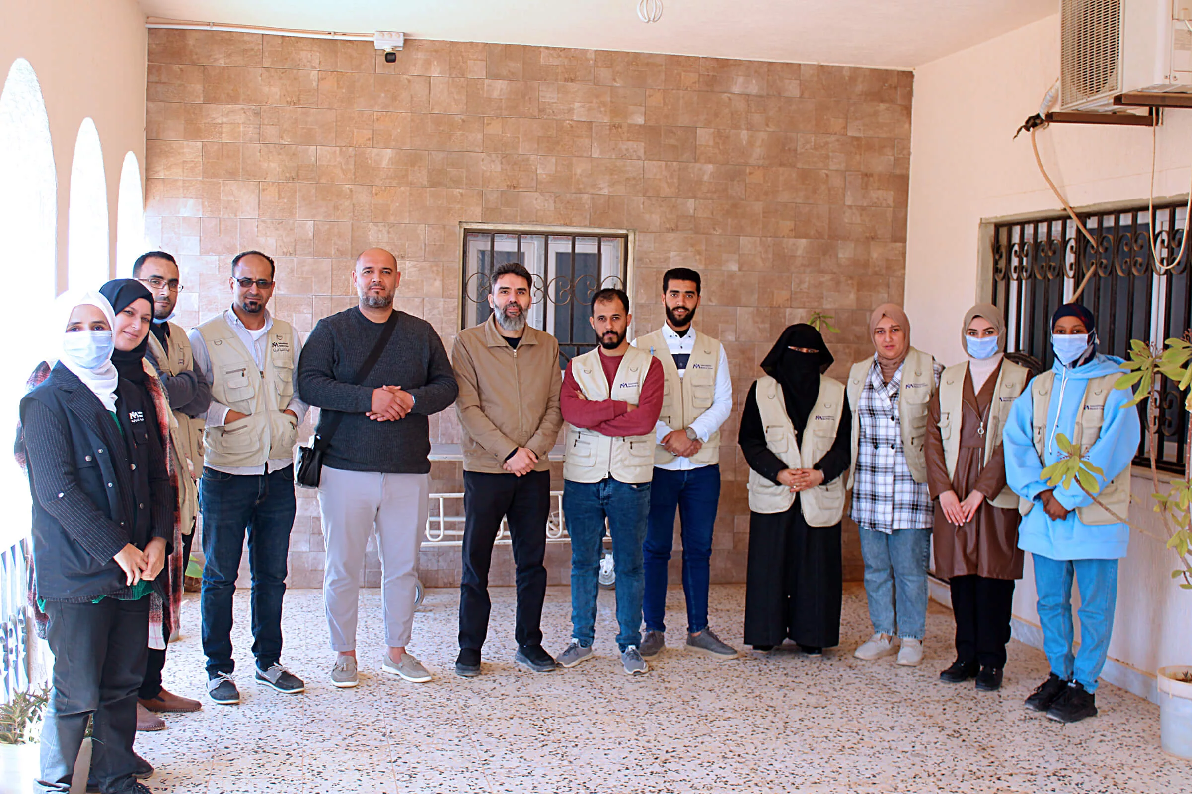 Several International Medical Corps staff members, including the emergency medical team, stand outside the Shuhada Algurgof primary health center. Dr. Mira is third from the right.