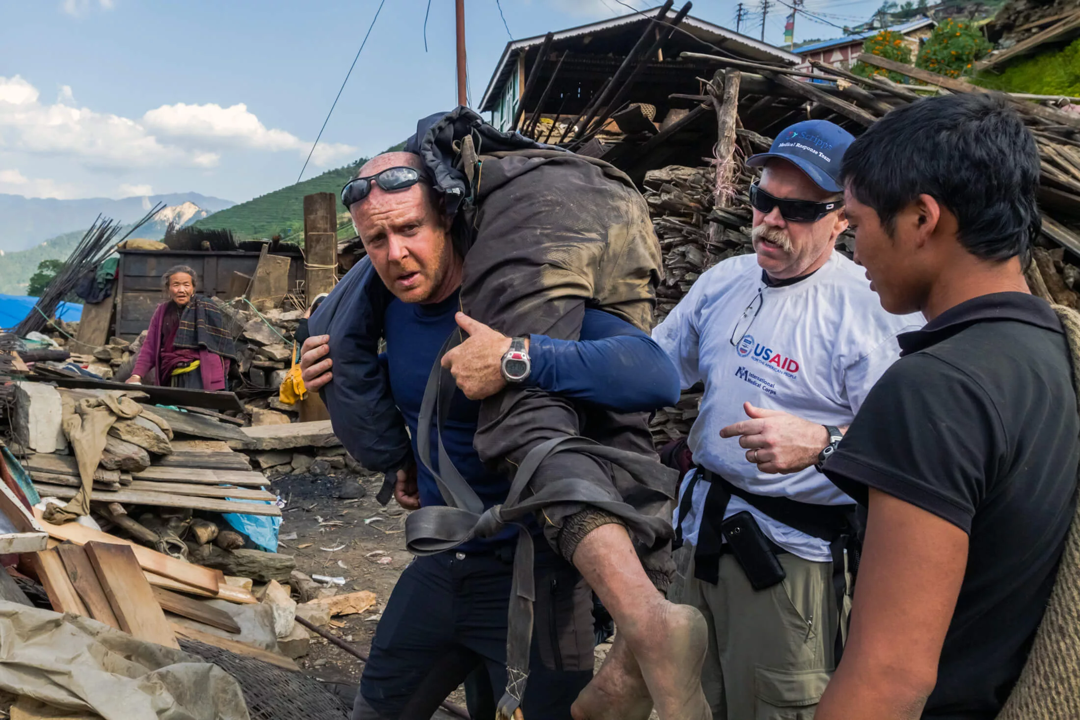 Dr. Michael Karch carries an injured man uphill during a rescue mission in Nepal.