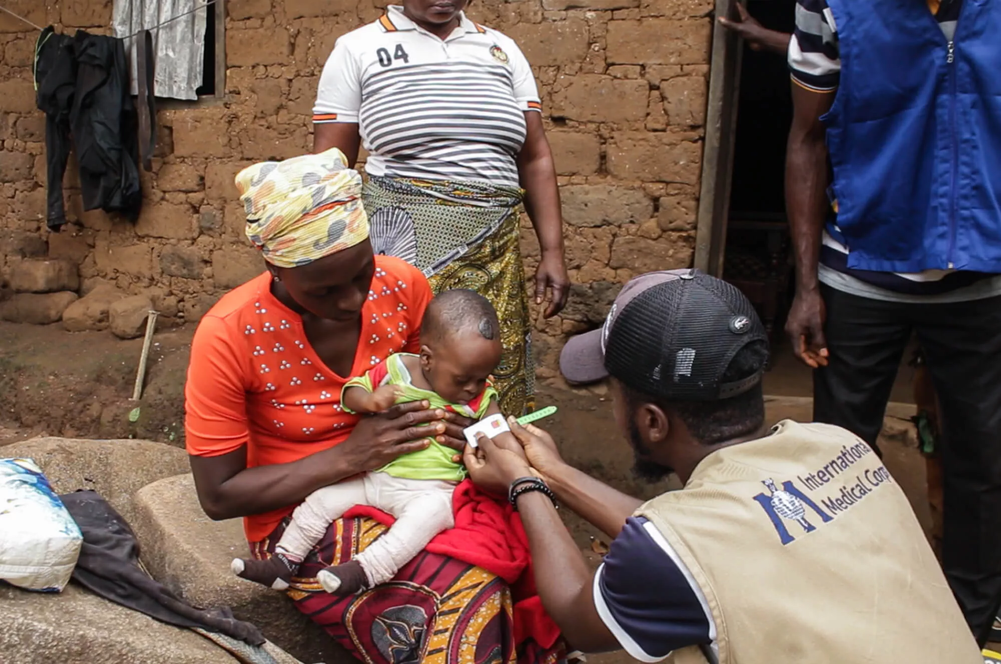 A staff member conducts a home visit to check for signs of malnutrition.