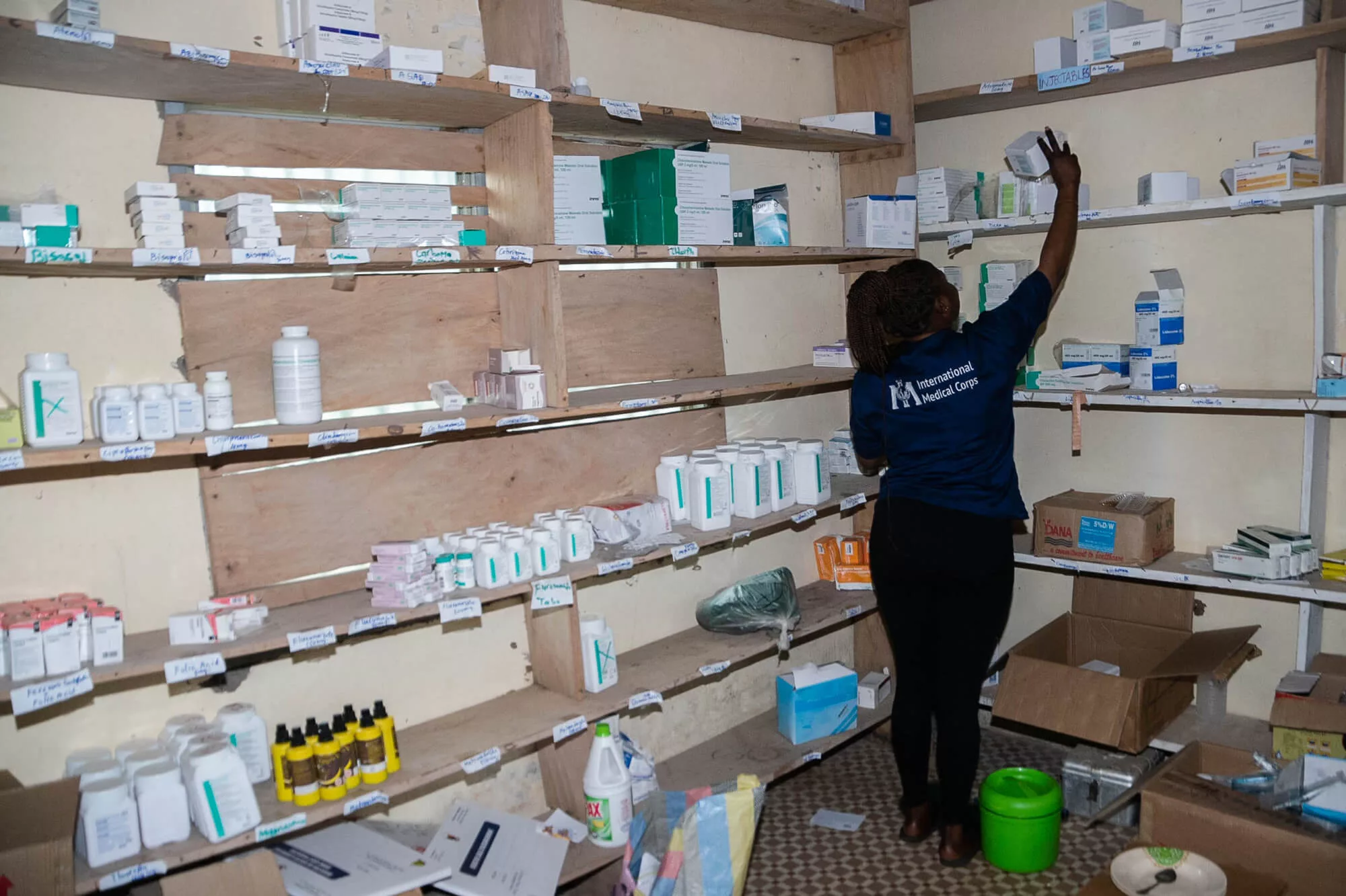A staff member stocks medicine at Buku Health Outpost.