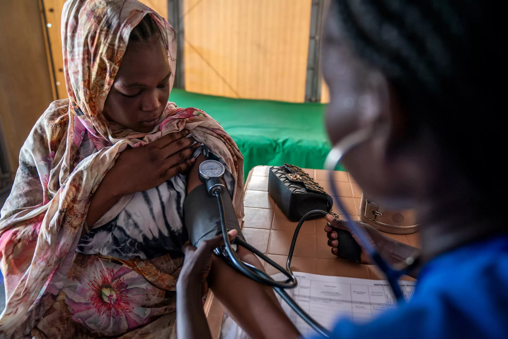 Midwife Nyapin Chol Put conducts a prenatal checkup with a patient at the health clinic in Renk, South Sudan.