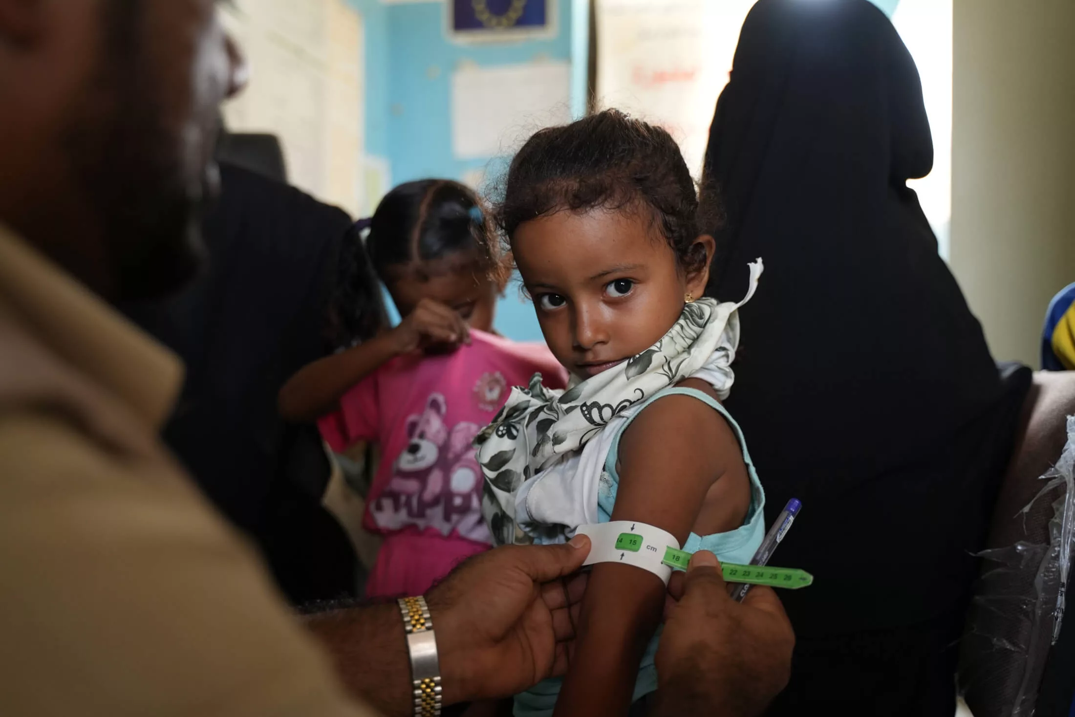 An International Medical Corps health and nutrition assistant measures 2-year-old Ateekah Alaa’s mid-upper arm circumference (MUAC) to check her nutritional status.