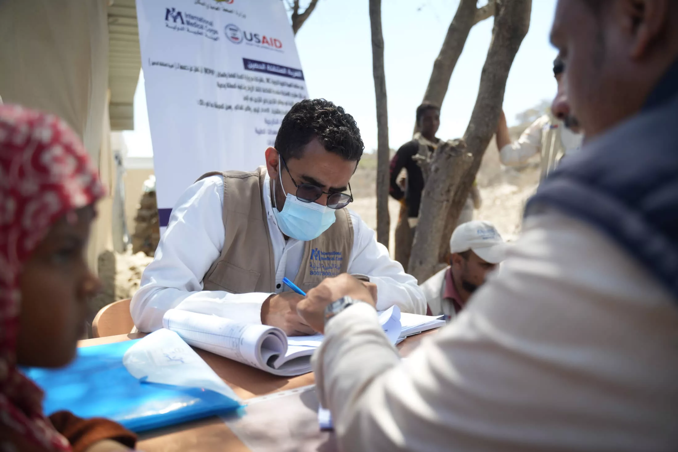 Doctor Ali Mohammed Msaad Hussein registers families living in the camp for medical consultations..